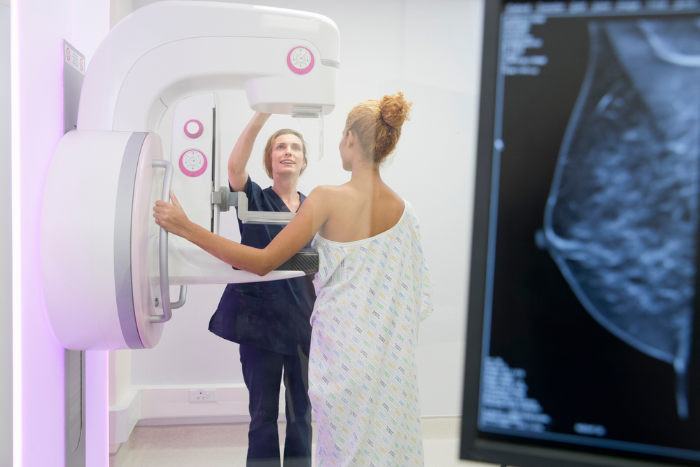 radiographer is operating the mammogram system while patient is waiting