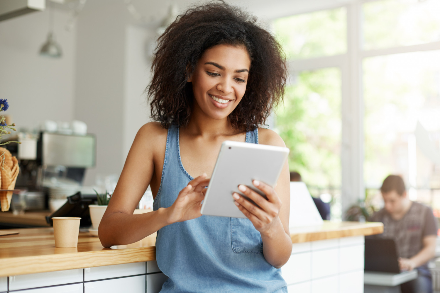 pretty-african-female-student-resting-cafe-smiling-looking-tablet-screen