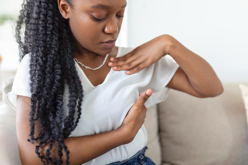 woman performing self breast exam